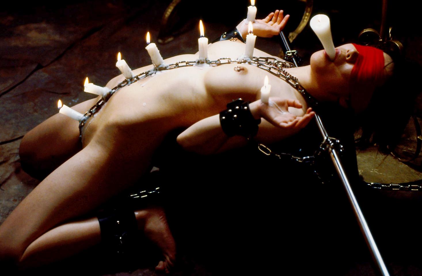 Chained BDSM slave in a hot candle and wax fetish session